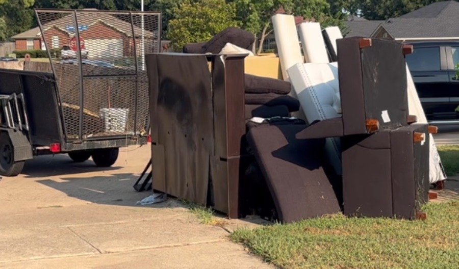 Curbside pile of furniture and mattresses loaded for junk removal pickup in Hemet, CA